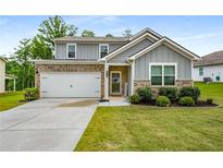 Charming two-story home with brick and gray siding, a well-manicured lawn, and a two-car garage at 510 Curry Ridge Ct, Locust Grove, GA 30248