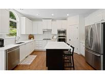 Bright kitchen with white cabinets, stainless steel appliances, and a large center island at 4108 Wyndam Hill Dr, Suwanee, GA 30024
