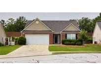 Charming single-story brick home with a manicured lawn and attached two-car garage at 942 Village View Cir, Loganville, GA 30052