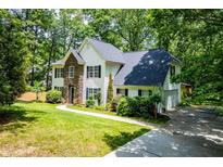 Charming two-story home with stone accents and a well-manicured lawn surrounded by mature trees at 97 Coral Dr, Whitesburg, GA 30185