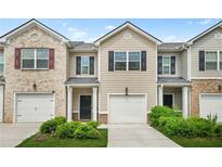 Traditional townhome featuring neutral siding, a one-car garage, and manicured landscaping at 4076 Sonoma Wood Trl, Decatur, GA 30034