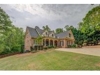 Elegant brick home with a manicured front lawn and inviting covered front porch at 95 Weslyan Way, Oxford, GA 30054