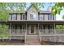 Charming home featuring a welcoming front porch and manicured landscaping at 21 Wisteria Run, Hiram, GA 30141