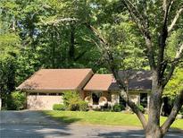 Charming single-story home with a lush green lawn and a welcoming front porch sitting area at 210 North Trce, Alpharetta, GA 30009