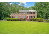 Traditional brick home with a manicured lawn and mature trees at 1777 E Gate Trl, Stone Mountain, GA 30087