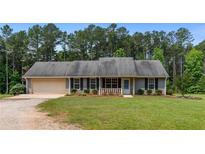Charming single-story home with a well-maintained lawn and an attached two-car garage at 4841 Partee Trl, Social Circle, GA 30025