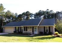 Charming single story home with manicured lawn, attached garage, and inviting front porch at 4841 Partee Trl, Social Circle, GA 30025