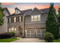Stunning two-story home featuring a brick facade, gray siding, and a well-manicured lawn at 667 Creswell Park, Smyrna, GA 30082