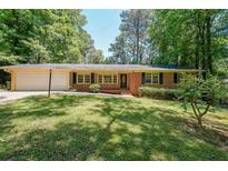 Charming brick ranch home with a well-maintained lawn and mature trees at 213 Linda Dr, Tucker, GA 30084