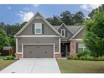 Charming Craftsman-style home with a well-maintained lawn, gray siding, brick accents, and an attached two-car garage at 2256 Long Bow Chase Nw, Kennesaw, GA 30144