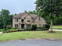 Lovely two-story brick home with manicured lawn, mature trees, and a charming front entrance at 602 Davenport Pl, Canton, GA 30115