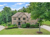 Beautiful brick home featuring lush landscaping, a well-manicured lawn, and a welcoming entrance at 602 Davenport Pl, Canton, GA 30115