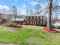 Charming two-story brick home with a manicured lawn and classic architectural details at 4076 Shady Nw Cir, Lilburn, GA 30047