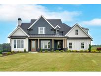 Striking two-story home featuring a modern farmhouse design with a covered front porch and expansive lawn at 152 Palisade Dr, Rydal, GA 30171