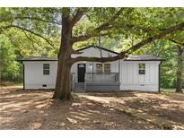 Charming renovated ranch home with a cozy front porch and mature trees providing ample shade at 2871 Tucker Mill Sw Rd, Conyers, GA 30094