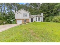 Charming two-story home features a well-maintained lawn and attached one-car garage at 2426 Corner Shoals Dr, Decatur, GA 30034