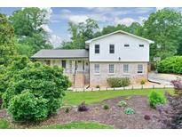 Charming two-story home with a brick foundation, complemented by a beautifully landscaped front yard with mature shade trees at 281 Lakeshore Ne Dr, Marietta, GA 30067