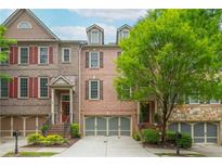Charming brick townhome with manicured landscaping, attached garage, and inviting curb appeal at 2025 Eagle Rdg, Roswell, GA 30076