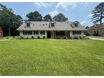 Charming single-story home with a well-manicured lawn and inviting curb appeal on a sunny day at 2834 Columbia Dr, Decatur, GA 30034
