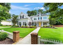 Charming two-story home with landscaped yard, inviting entrance, and well-manicured lawn on a sunny day at 4115 Williams Point Dr, Cumming, GA 30028