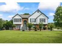 Charming two-story home features a well-manicured lawn and inviting exterior with brick and siding accents at 4914 Watson Mill Ct, Loganville, GA 30052