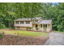 Charming two-story home with a cozy covered porch and a well-maintained lawn surrounded by mature trees at 1034 Sandy Ridge Rd, Mcdonough, GA 30252