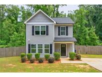 Charming two-story home with gray siding, black shutters, and a well-maintained front yard with landscaping at 6375 Eidson Dr, Cumming, GA 30041
