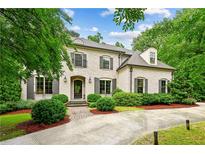 Charming brick home featuring dark shutters, manicured landscaping, and brick-paved driveway at 2115 Howell Mill Nw Rd, Atlanta, GA 30318