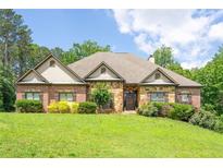 Charming brick and stone home with manicured lawn and mature trees in a desirable neighborhood at 799 Wagon Trl, Woodstock, GA 30188
