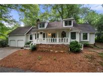 Charming home featuring a welcoming front porch and well-maintained landscaping at 1104 Warrenhall Ne Ln, Brookhaven, GA 30319