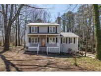Charming two-story home with a welcoming front porch and neatly maintained front yard surrounded by mature trees at 3271 Sutcliffe Nw Rdg, Marietta, GA 30064