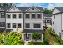Charming three-story townhouse with gray siding and a well-manicured front yard at 429 Stovall Pl, Woodstock, GA 30188