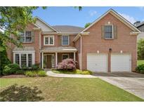 Charming two-story brick home featuring a manicured lawn and attached two-car garage at 514 Augusta Dr, Canton, GA 30115