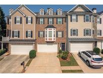 Charming townhome with attached garages, neat landscaping and neutral-colored exterior at 6004 Turfway Park Ct, Sugar Hill, GA 30518