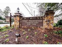 Stone entrance sign for The Summit Condominium Homes featuring landscaped flower beds and available homes signage at 5157 Roswell Rd # 1, Atlanta, GA 30342