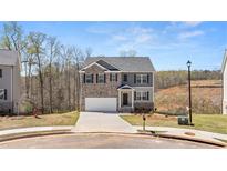 Charming two-story home with brick and gray siding, complemented by a well-manicured lawn at 620 Lobelia Way, Locust Grove, GA 30248