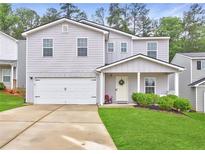 Charming two-story home with a well-maintained lawn, covered porch, and attached two-car garage at 336 Freeman Cir, Villa Rica, GA 30180