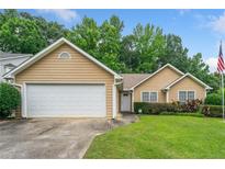 Charming single-story home with attached garage, manicured lawn, and an American flag waving proudly at 467 Ravinia Way, Lawrenceville, GA 30044