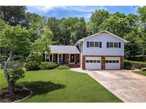 Charming split-level home with a well-manicured lawn and a two-car garage, nestled in a wooded area at 5778 Little Oak Trl, Stone Mountain, GA 30087