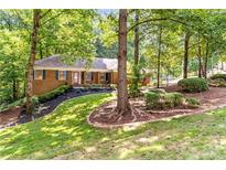 Charming brick home with mature trees and landscaped front yard at 2166 Lake Ridge Ter, Lawrenceville, GA 30043