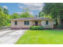 Charming brick home with a well-manicured lawn, inviting curb appeal, and beautiful landscaping at 61 Springside Se Dr, Atlanta, GA 30354
