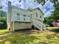 Charming home features a white exterior with a quaint front porch and a well-maintained lawn at 186 Grapevine Dr, Douglasville, GA 30134