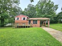 Exterior of two-story home featuring front deck and covered parking at 6616 King George Way, Morrow, GA 30260