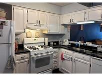 Traditional kitchen with white cabinets and appliances, offering a clean, functional space at 6620 Wellington Sq, Norcross, GA 30093