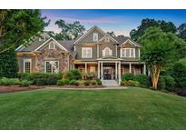 Charming two-story home with a combination of stone and siding, complemented by lush landscaping and a well-manicured lawn at 1220 Waterfall Nw Ln, Acworth, GA 30101