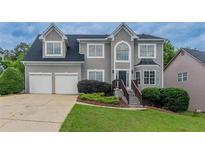 Charming two-story home with a well-manicured lawn, two-car garage, and a classic gray stucco facade at 1706 Brandon Lee Sw Way, Marietta, GA 30008