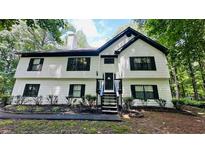 Charming two-story home featuring a symmetrical facade, black shutters, and lush landscaping at 2985 Heather Stone Way, Lawrenceville, GA 30043