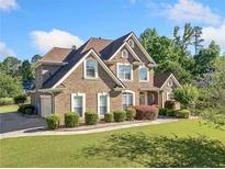 Beautiful brick home with manicured lawn, mature trees, and inviting curb appeal at 2900 Sutton Pl, Conyers, GA 30013