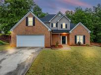Charming two-story brick home with manicured lawn and attached two-car garage at 3190 Water Brook Sw Dr, Conyers, GA 30094