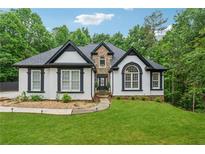Charming two-story home with black and white trim, stone accents, and a lush green lawn at 827 Holly Rdg, Canton, GA 30115